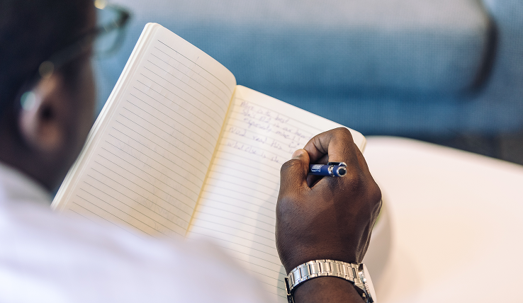 Man Writing in Notebook